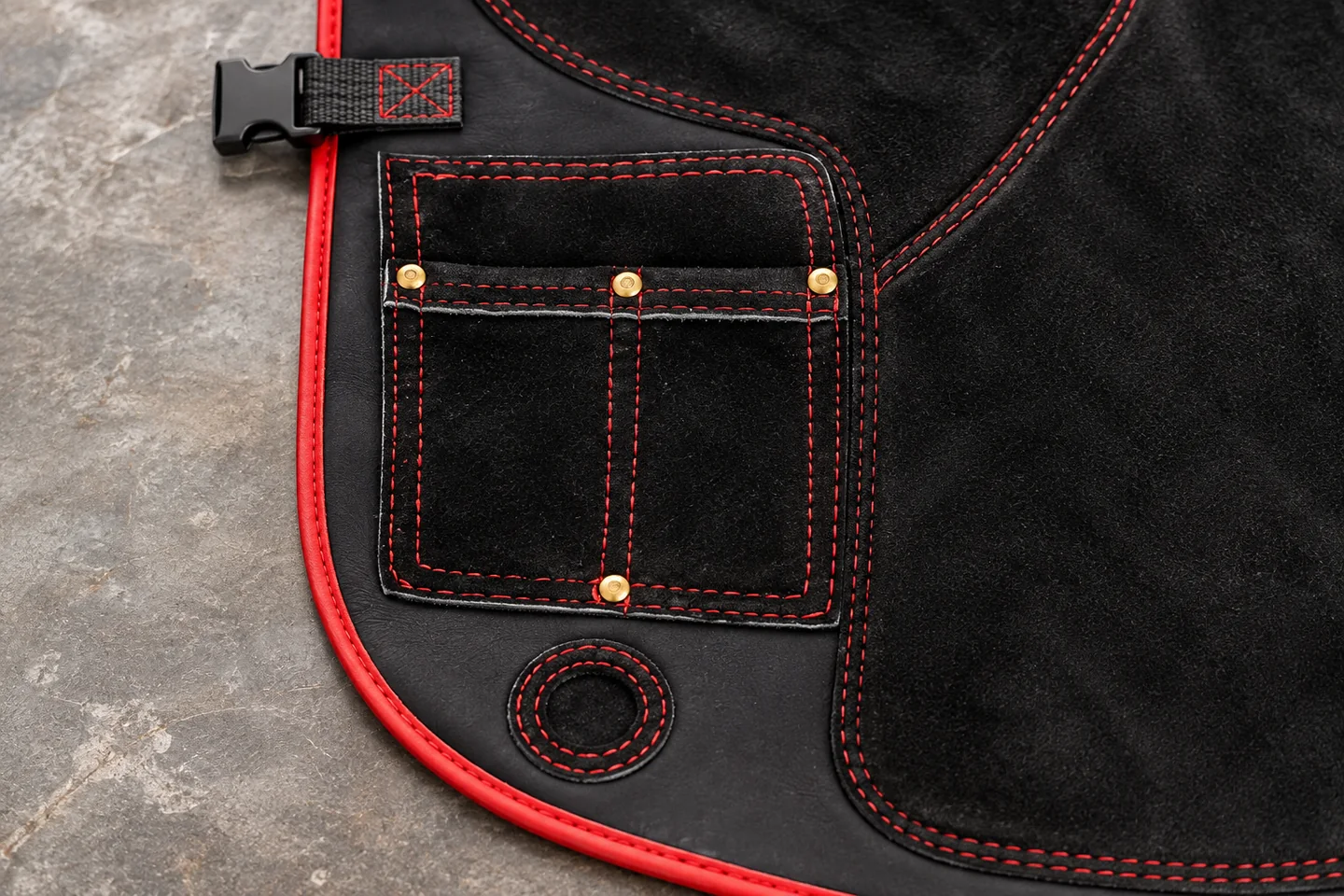Detail of split tool pockets, stitching and rivets on a farrier apron