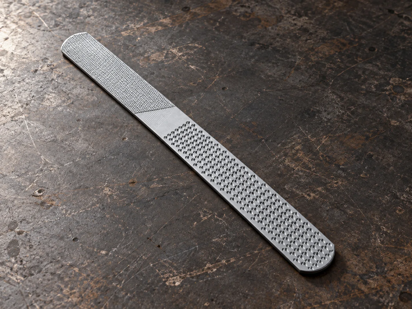 Flat handleless hoof rasp with coarse and fine surface areas on a sample bench
