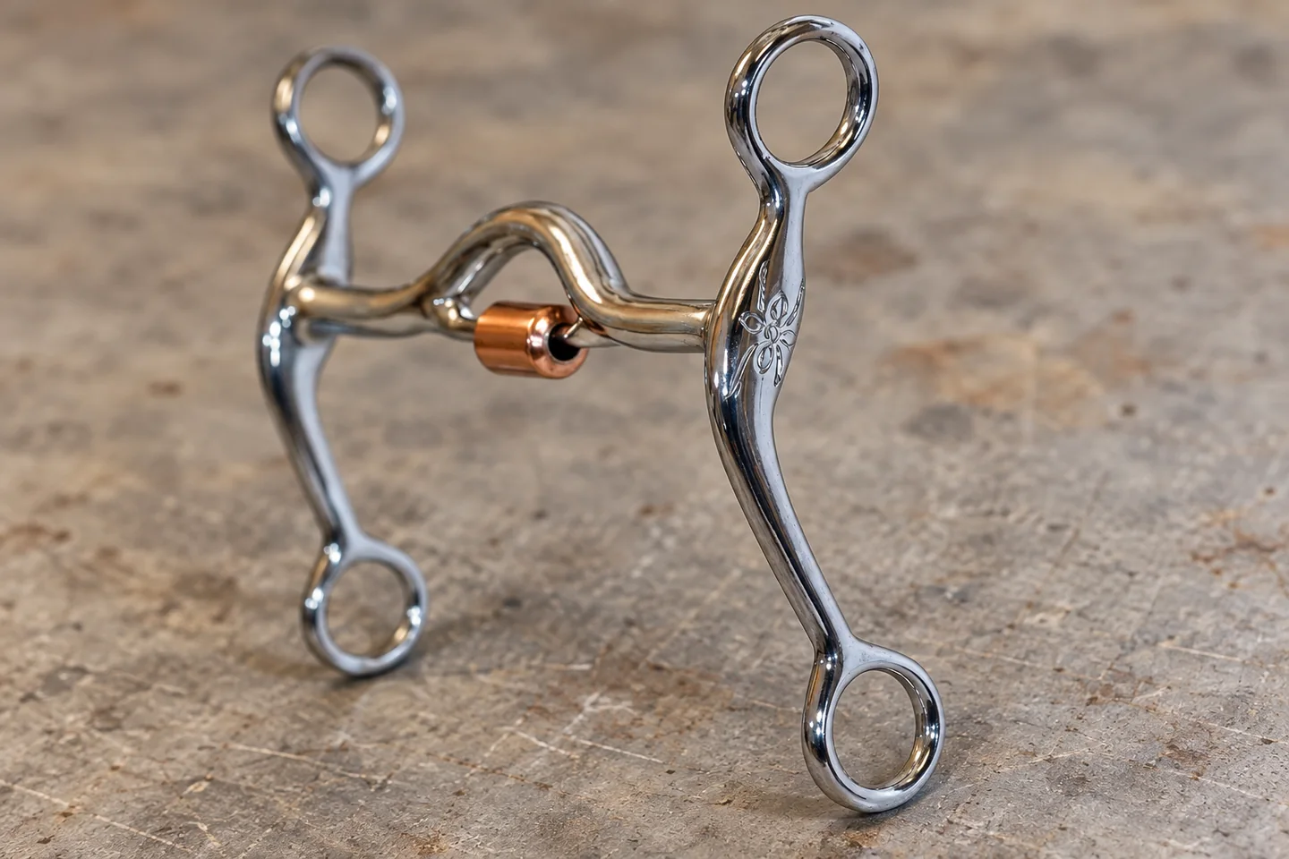 Close view of a curved engraved shank cheek and its attachment rings