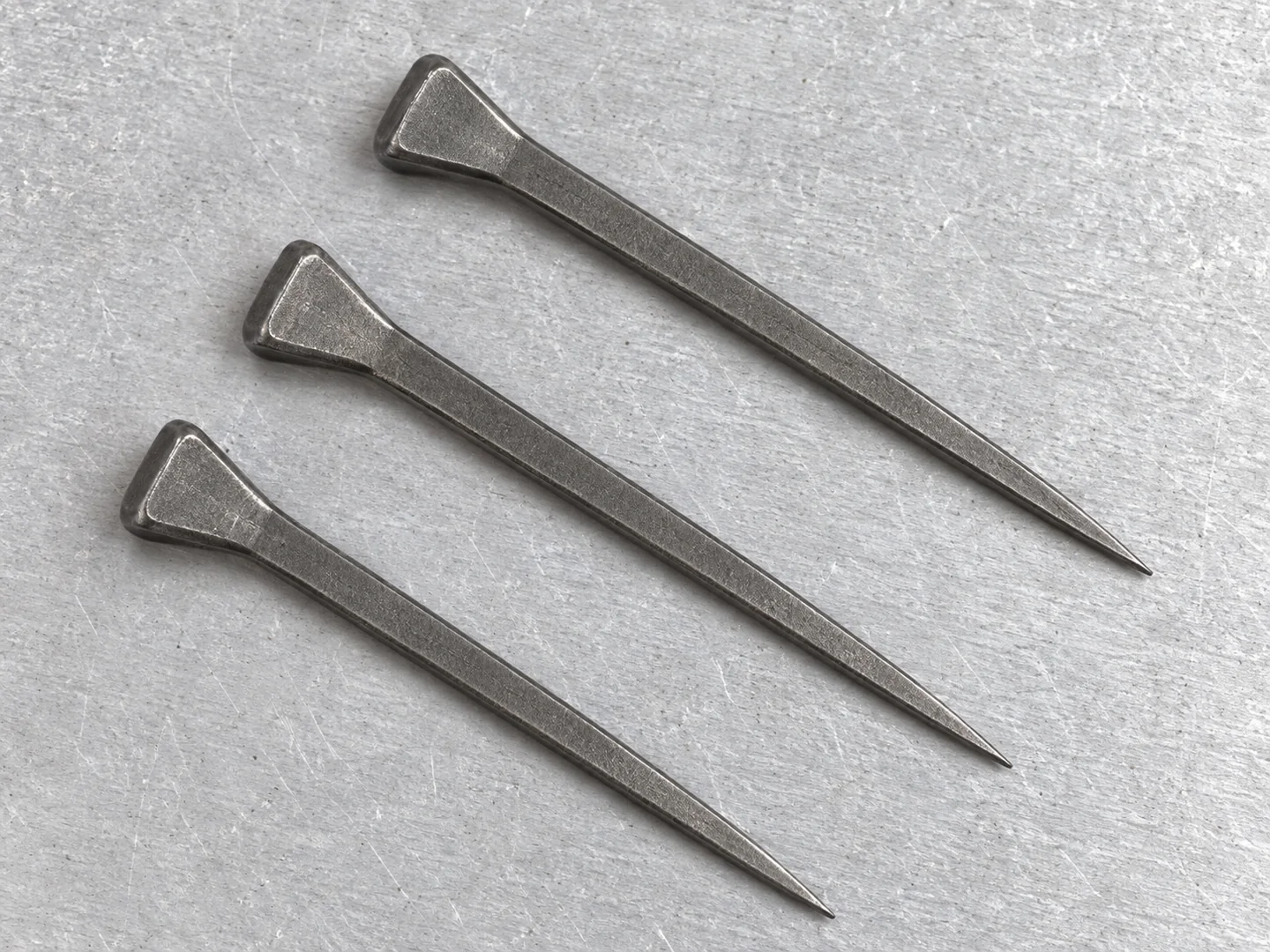 Close view of horseshoe nail heads and flat tapered shanks