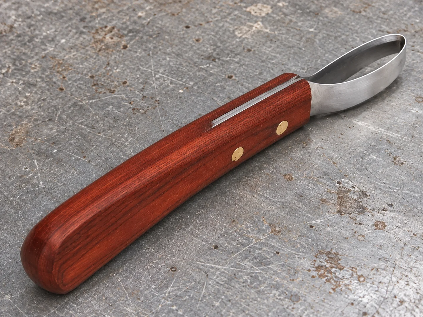 Closed oval metal loop blade joined to a wooden hoof knife handle