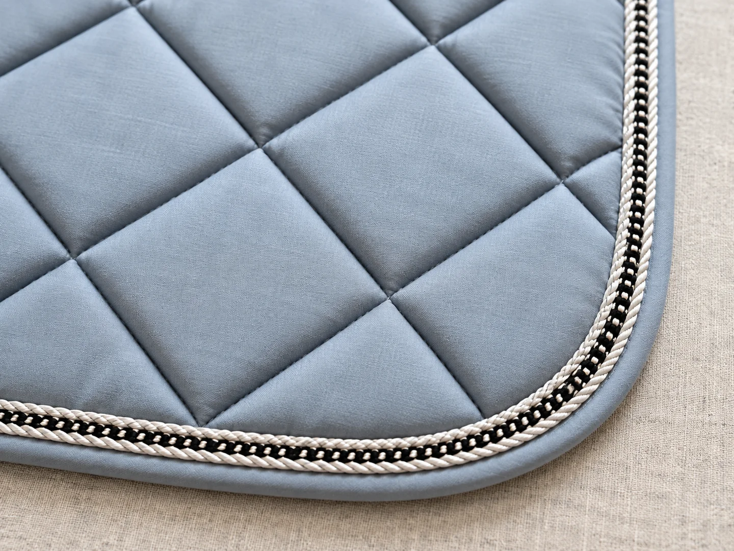 Diamond quilting and decorative piping around a saddle pad corner